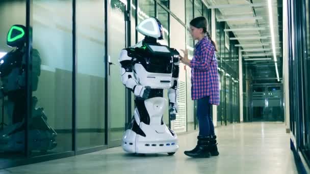 10代の女の子は人間のようなロボットを探索しています — ストック動画