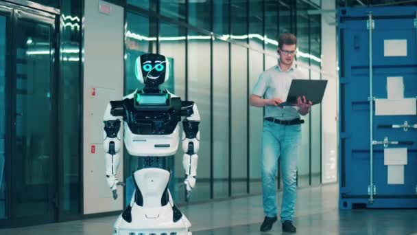 エンジニアの専門家は、ロボットと話すためにラップトップを使用しています — ストック動画