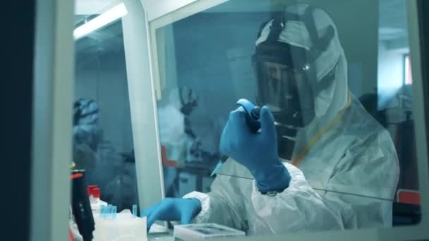 A Quantorium dolgozója egy tesztmintát vizsgál. Antibodák kutatási cocnept, covid-19 coronavírus pandémia. — Stock videók
