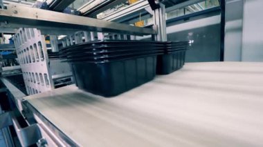 Plastik kaplar taşıyıcı bant tarafından taşınıyor.