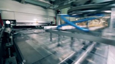 Fabrika makinesi plastik konteynırları kaldırıyor.