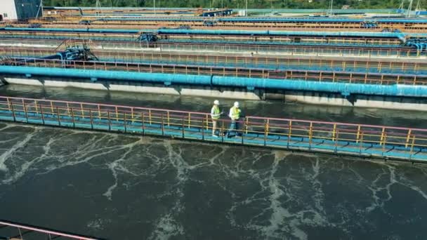 Gli ispettori stanno camminando lungo gli impianti di pulizia delle acque reflue. Trattamento acque reflue, concetto di trattamento acque reflue. — Video Stock