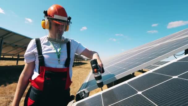 Concepto de electricidad renovable. Paneles solares están siendo perforados por un reparador — Vídeo de stock