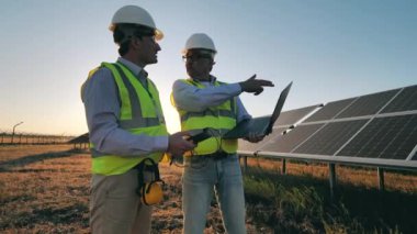 Erkek müfettişler güneş panellerinin voltaj seviyesini kontrol ediyorlar.