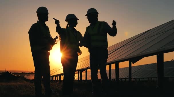 Concepto de energía renovable. Grupo de expertos discuten un proyecto solar al atardecer — Vídeo de stock