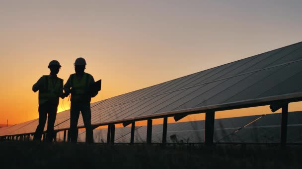 Bezpečnostní inspektoři mluví o solárních bateriích při západu slunce — Stock video