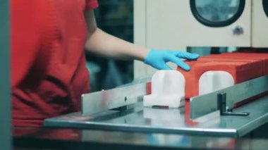 Fabrika işçisi bir fabrikada kırmızı kağıt peçete sıralıyor.