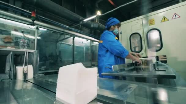 Female factory worker placing facial tissues onto a conveyor belt — Stock Video