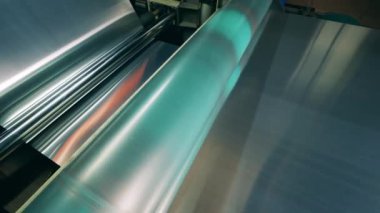 Metalik madde endüstriyel bir makine tarafından taşınıyor.