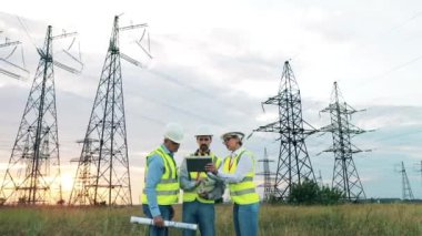 Elektrik santrali işçileri güpegündüz geniş bir tarlayı inceliyor.