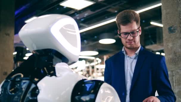 Бизнесмен трогает бионического робота. Робототехника, инновационная концепция. — стоковое видео