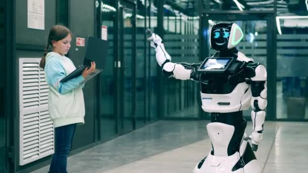 Молодая девушка управляет роботоподобной машиной с ноутбуком — стоковое видео