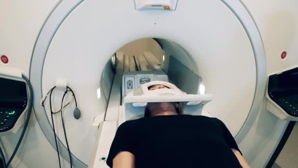 CT-Scanner, in den ein männlicher Patient eingezogen wird — Stockvideo