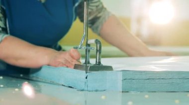 Kumaş parçası kenarlarından jiletle kesiliyor.