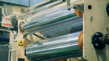 İnce plastik madde, dönen taşıyıcıdan geçiyor.