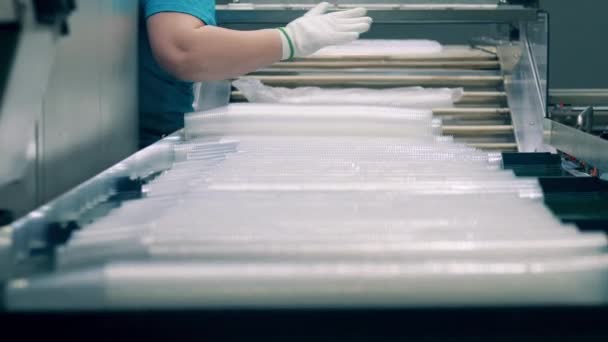 Fabrika çalışanı plastik bardakları poşetlere koyuyor. — Stok video