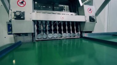 Endüstriyel makine taşıyıcıya plastik bardaklar bırakıyor.