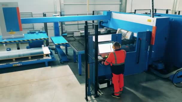 Técnico masculino está operando uma grande máquina de corte. Produção industrial fábrica interior. — Vídeo de Stock