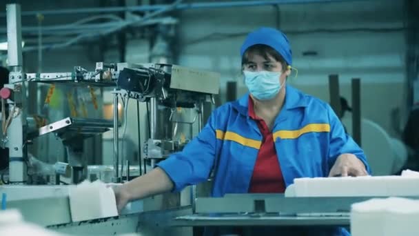 Працівник фабрики жіночого паперу розміщує та сортує тканини обличчя — стокове відео