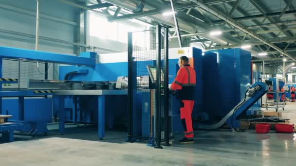 Fabrieksschaarmachine onder toezicht van een mannelijke arbeider. Industriële productie fabrieksinterieur. — Stockvideo