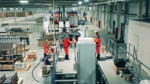 공장 기술자들이 손으로 냉장고를 조립 한다 — 비디오