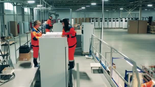 Сотрудники фабрики производят холодильники — стоковое видео