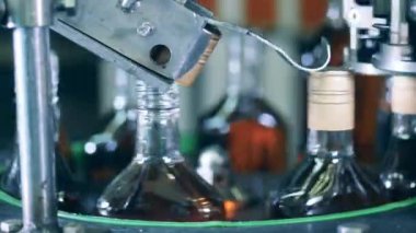 Fabrika mekanizması içki şişelerine kapak koyuyor.