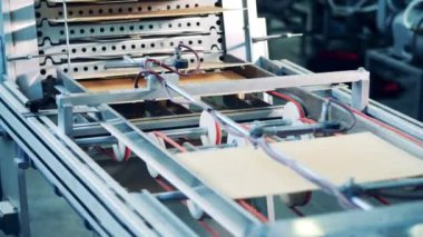 Taşıyıcı makine waffle tabakalarını değiştiriyor. Waffle 'lı üretim hattı.