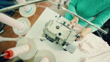Bir tekstil işçisi tarafından işletilen dikiş makinesinin üst görünümü