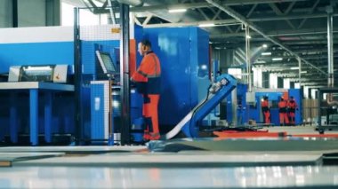 Buzdolabı fabrikasında çalışan erkek bir fabrika işçisi modern bir makine kullanıyor.