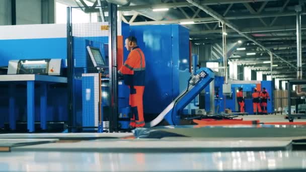 Trabajador de fábrica masculino en una fábrica de refrigeradores que opera una máquina moderna — Vídeo de stock