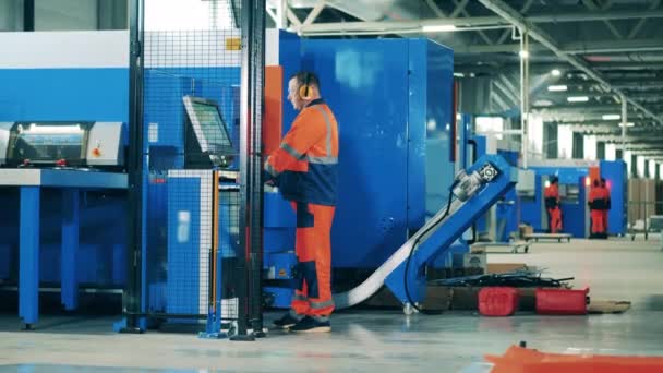 Factory worker operating an industrial machine on a modern assembly line — Stock Video