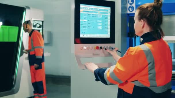 Vrouwelijke ingenieur die een touchscreen gebruikt om het productieproces in een fabriek te controleren — Stockvideo
