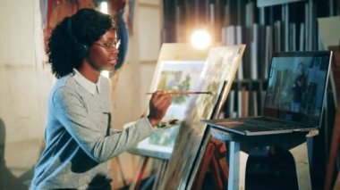 Afrikalı kadın bir resim çizmek için internetten özel ders kullanıyor.