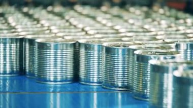 Fabrika taşıyıcısında bir yığın teneke kutu var.