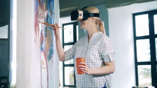 Eine Dame mit VR-Brille benutzt beim Malen einen Pinsel — Stockvideo