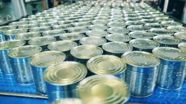 Üzerinde teneke kutular olan taşıyıcı yığılıyor.