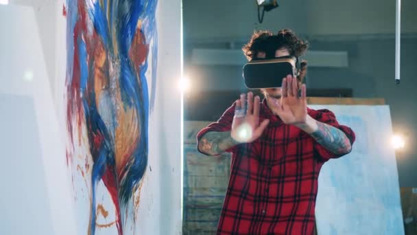 Junger Mann trägt VR-Brille im Kunstatelier — Stockvideo