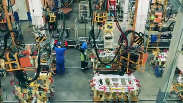 近代的な溶接機を使用して自動車部品を溶接する自動車工場の労働者 — ストック動画