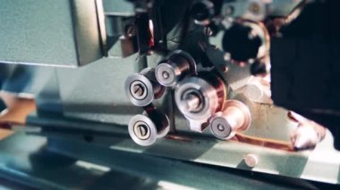 Eski bir film projektörünün makaralarını yakın plan çekimde döndürür