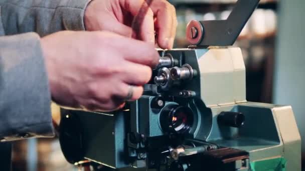 Gammal film tejp sätts in i projektorn av en specialist — Stockvideo