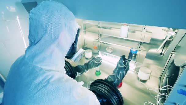 실험실 전문가는 실험 샘플을 분석하기 위해 진공 캐비닛을 사용 한다. Covid-19, coronavirus 연구소, 바이러스, 전염병 컨셉트. — 비디오