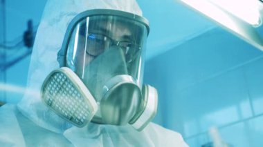 Dolap camından çekilen tehlikeli madde giysisi laboratuvar uzmanı.