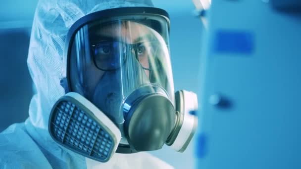 A férfi specialista vegyvédelmi maszkot visel a laborban. Pandémia, vírus, tudományos fogalom. — Stock videók