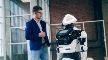 İş adamı bir sibernetik droidle sohbet ediyor.