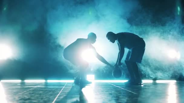 Giocatore maschile sta cercando di prendere un pallone da basket lontano dal suo rivale. Giocatori di basket al buio. — Video Stock