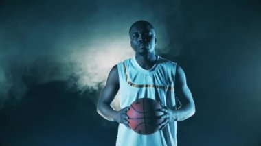 Basketbolcu erkek oyuncu kameraya bakıyor.