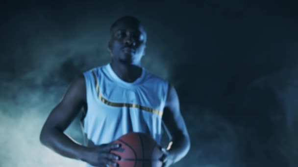 Jogador africano está andando com um basquete enquanto olha para a câmera — Vídeo de Stock