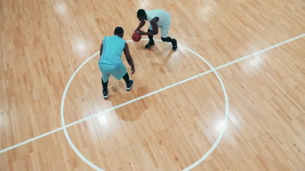 Ginásio com dois jogadores de basquete de etnia africana tendo uma prática — Vídeo de Stock