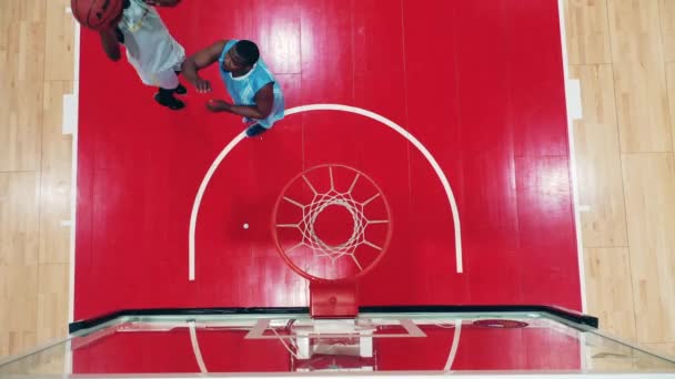 Deux hommes d'ethnie africaine lancent un ballon de basket dans une vue d'ensemble — Video